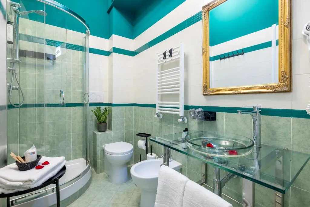 Private bathroom with a glass shower, vessel sink and teal tiles
