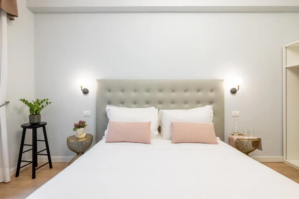 Double bed with blush cushions and gold side tables