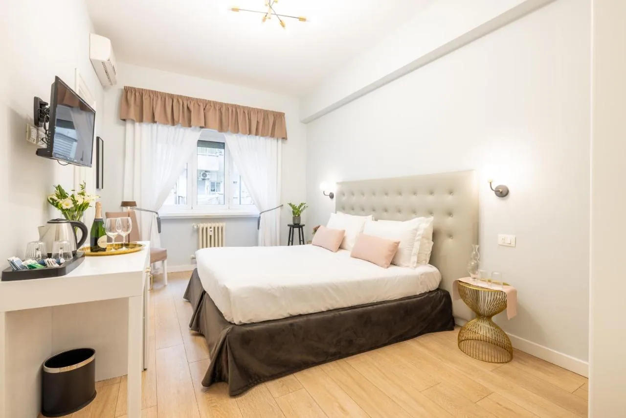 Double room with a beige headboard, a wall-mounted television and tea facilities