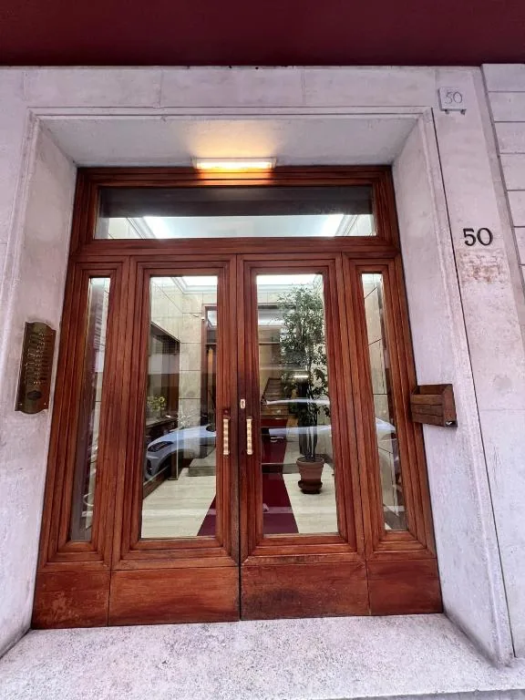 The entrance at number 50, with wooden doors opening onto the street