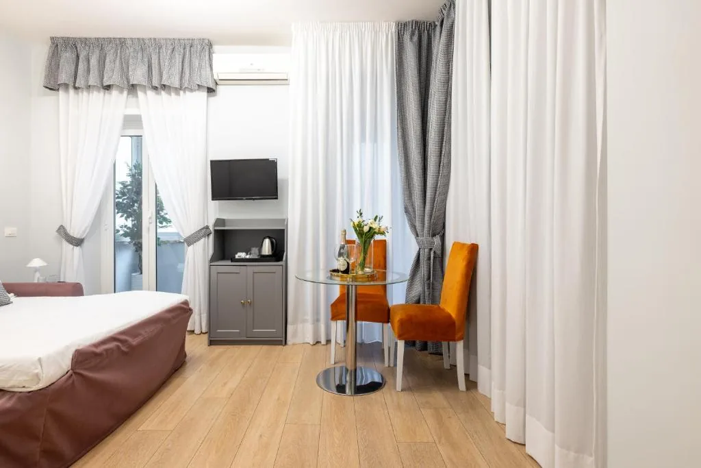 Seating area with orange chairs, a glass table and a door to the balcony